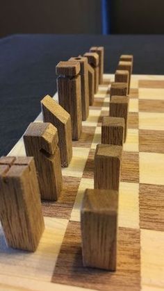 a wooden chess board with pieces arranged in the shape of cubes on each side