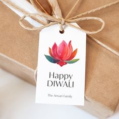 a gift wrapped in brown paper with a tag that says happy diwali