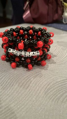 red and black bracelets are sitting on a bed