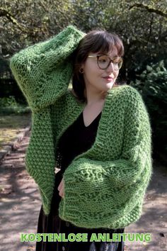 a woman wearing glasses and a green knitted cardigan