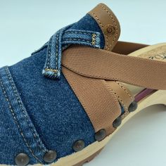 a pair of blue jean shoes with brown straps