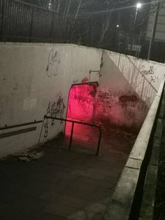 a wall with graffiti on it and a red light in the corner next to it