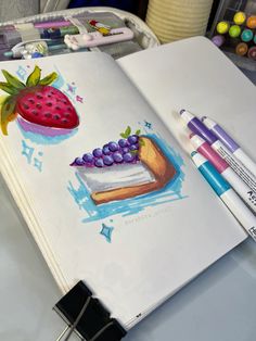 an open notebook with watercolors and crayons on it