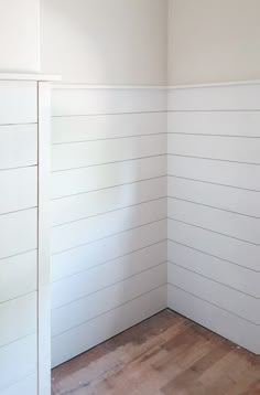 an empty room with white walls and wood flooring on one side, the wall is painted in white