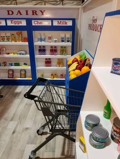 an empty grocery cart in a store filled with food