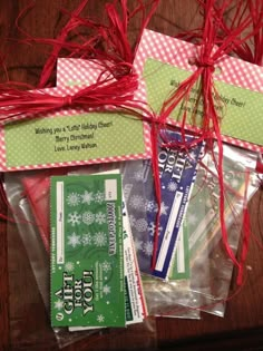 some red and green items wrapped in clear plastic on top of a wooden table next to each other