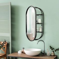 a bathroom sink sitting under a mirror next to a wooden table with a bowl on it