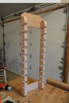 a wooden structure sitting on top of a hard wood floor next to tools and construction equipment