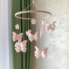 a wind chime with pink and white butterflies hanging from it