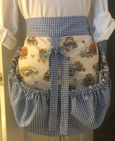 the apron is made out of blue and white gingham checkered fabric with cars on it