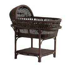 a brown wicker baby crib sitting on top of a table