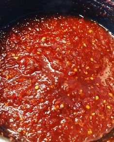 a large pot filled with sauce sitting on top of a stove