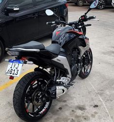 a motorcycle parked in a parking lot next to a car