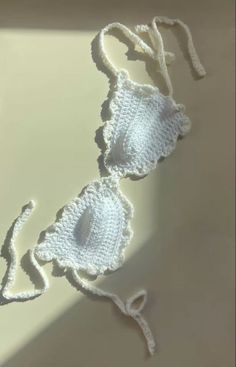 two crocheted bras laying on top of a white table next to each other