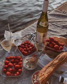 a table with bread, strawberries and wine on it