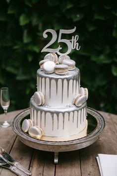 a wedding cake with white icing is on a wooden table