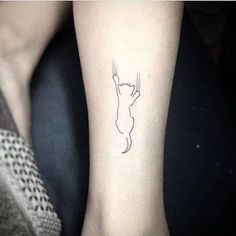 a small cat tattoo on the left wrist and foot, with a line drawing of a cat