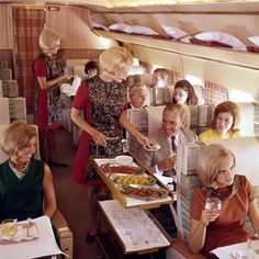 an airplane cabin filled with people serving food and drinks to each other on trays