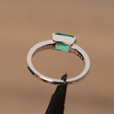 It is lab grown emerald ring, the main stone is about 5mm*7mm, emerald cut, weight about 0.85 carats.The basic metal is sterling silver and plated with rhodium.To change the metal to a solid gold (white/rose) or platinum is also available, please ask for a quotation if you want.You can also go to my shop Home for more elegant rings: https://www.etsy.com/shop/godjewelry?ref=hdr_shop_menuEmerald is May birthstone.More emerald rings:https://www.etsy.com/shop/godjewelry?ref=hdr_shop_menu&section Green Emerald Cut Birthstone Ring With Halo Setting, Silver Emerald Cut Emerald Birthstone Ring, Emerald Cut Green Birthstone Ring With Halo Setting, Emerald Cut Emerald Ring With Halo Setting, Silver Emerald Cut Birthstone Ring, Silver Radiant Cut Emerald Ring For May Birthstone, Radiant Cut Silver Emerald Ring For May Birthstone, White Gold Emerald Ring Square Cut, White Gold Emerald Birthstone Ring In Emerald Cut