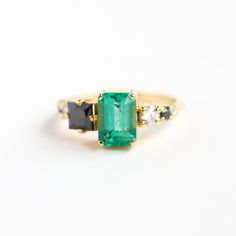 𝗦𝗜𝗟𝗩𝗜𝗔 𝗘𝗠𝗘𝗥𝗔𝗟𝗗 𝗖𝗟𝗨𝗦𝗧𝗘𝗥 𝗥𝗜𝗡𝗚 Genuine emerald cluster ring. Unique and special emerald, black and white diamond engagement or statement ring.  READY TO SHIP in 18k yellow gold, US 5.75.  𝗗𝗘𝗧𝗔𝗜𝗟𝗦 𝗠𝗔𝗜𝗡 𝗦𝗧𝗢𝗡𝗘 𝗚𝗲𝗺𝘀𝘁𝗼𝗻𝗲: Emerald 𝗖𝗼𝗹𝗼𝗿: Intense green 𝗦𝗵𝗮𝗽𝗲: Emerald 𝗖𝘂𝘁: Emerald 𝗠𝗲𝗮𝘀𝘂𝗿𝗲𝗺𝗲𝗻𝘁: 8.2x6.1 mm (approx. 1.45 ct) 𝗦𝗜𝗗𝗘 𝗦𝗧𝗢𝗡𝗘𝗦 Black Diamond, square, princess cut, 5.00 mm (1) Black Diamond, round, brilliant cut, 2.00 mm Emerald Cut Emerald Ring, Diamond Emerald Ring, Smaragd Ring, Metric System, Emerald Color, Emerald Engagement Ring, Diamond Cluster Ring, Silver Pieces, Ring Unique