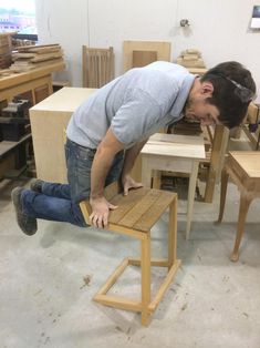 a man leaning over a wooden bench in a shop