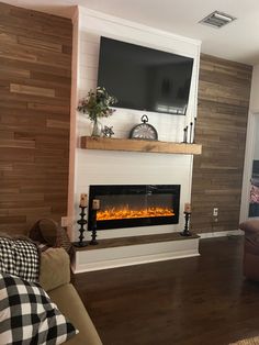 a living room filled with furniture and a flat screen tv mounted on the wall above a fire place