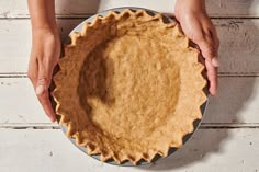 a person holding a pie crust in their hands