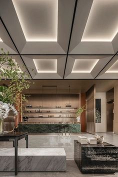 an elegant lobby with marble tables and planters