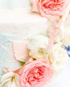 a close up of a cake with flowers on the top and bottom layer, in pastel colors