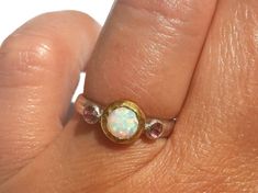 Opal Ring - Gold and Silver Ring - White Opal Pink Zircon Ring - Stackable Ring - Fire Opal Ring - 24k Gold - Opal Engagement Ring - Pink Zircon - Pink Ring. A lovely Opal (measures about 7 mm with the gold bezel around), with lots of pinks greens and more, is set in 24k solid gold, with small faceted pink Zircon (3 mm each) set in sterling silver on each side. The band is half round, hammered sterling silver (3 mm wide). Made to order in your size (Please pick your ring size in the drop-down me Pink Opal Rings With Gemstone, Pink Opal Gemstone Rings, Pink Opal Ring With Accent Stones As Gift, Pink Opal Gemstone Ring For Anniversary, Pink Opal Round Ring For Anniversary, Pink Opal Rings For Anniversary, Pink Multi-stone Birthstone Ring, Anniversary Pink Opal Round Ring, Gold Opal Engagement Ring