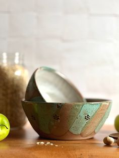 an apple sits next to two bowls on a table