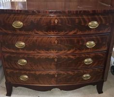 a wooden dresser with brass handles and drawers