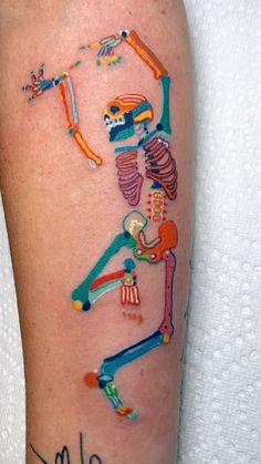 a colorful tattoo on the leg of a person with a baseball bat and skull in it