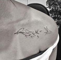 a woman's shoulder tattoo with birds on it