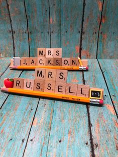 two wooden scrabbles with the words mrs jackson and mr russell written on them