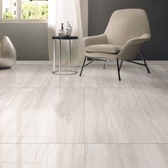 a chair and table in a room with white tile on the floor, walls and floors