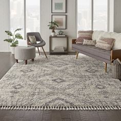 a living room filled with furniture and a rug on top of a hard wood floor