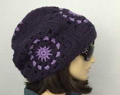 a mannequin head wearing a purple hat with flowers