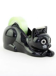 a black cat figurine with an apple in it's mouth and eyes