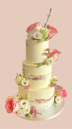 a three tiered cake with flowers on the top and bottom is white, pink and green