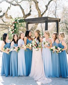 a group of women standing next to each other in front of a wooden gazebo