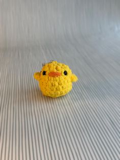 a small yellow stuffed animal sitting on top of a bed