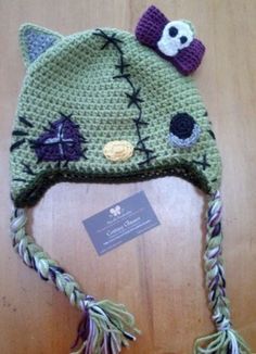 a crocheted hat with a cat on the front and a skull on the back