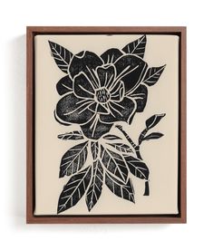 a black and white drawing of flowers in a wooden frame on the wall above it