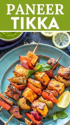 paneer tikka on a blue plate with lemon wedges