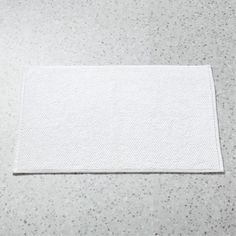 a white place mat sitting on top of a gray counter next to a knife and fork