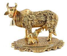 a golden cow and calf figurine on a stand