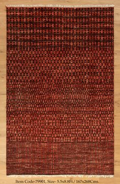 a red and black rug on top of a wooden floor