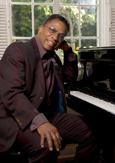 a man sitting at a piano in front of a window