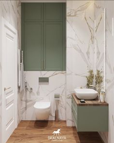 a bathroom with green cabinets and a white toilet next to a wooden counter top sink